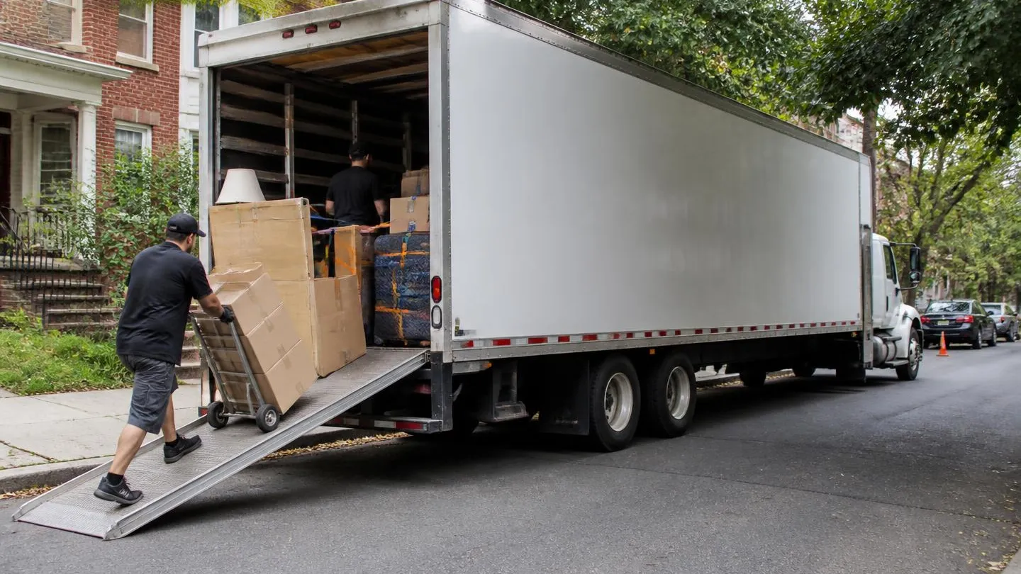 A long distance moving van being loaded on a residential street